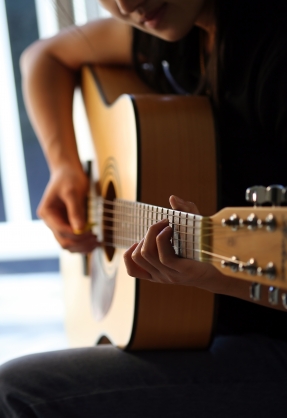 Girl playing the acoustic guitar